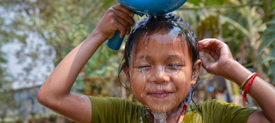 © UNICEF/Fani Llaurado Una niña se lava la cara en una instalación de agua recién abiera en Camboya.